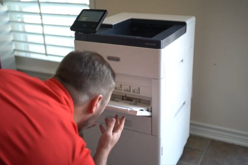 Osoba proverava unutrašnjost laserskog štampača pri pripremi za štampu
